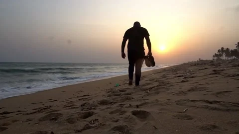 Man walking on the beach at Sunset Video stock 179710403