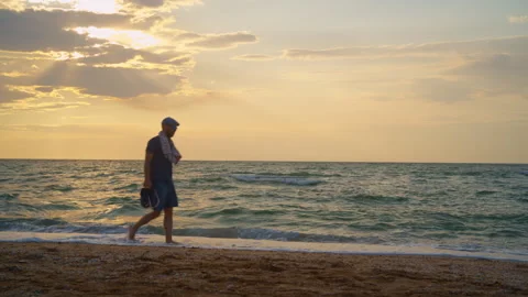Man Walking on Beach at Sunset Stock Footage 314127838