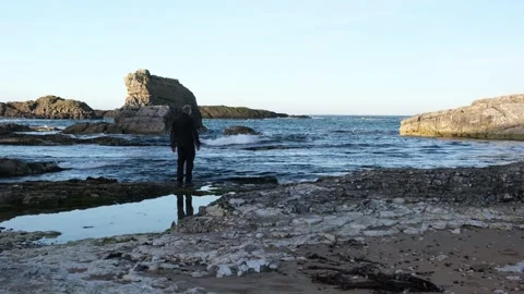 Man walking beside rock pools Causeway Coast seascape Stock-Footage 291998247