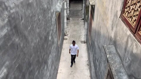 Man walking between old Mandarin houses Stock Footage 273188643