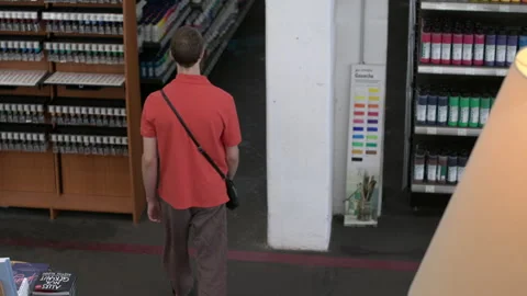 Man walking between shelves in a store Stock Footage 239357281
