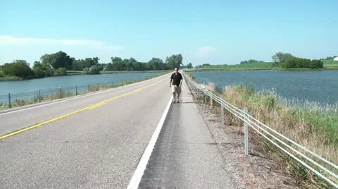 Man Walking Between Two Lakes Stockbeeldmateriaal 12598742