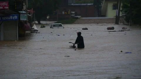 A man walking with a bicycle on a flooded way Stock Footage 286012336