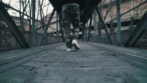 Man walking on a bridge in an abandoned building Stock Footage 86090302