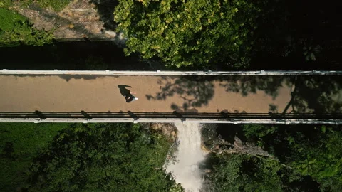 Man Walking On Bridge Above Waterfall. Top View Video stock 314747609