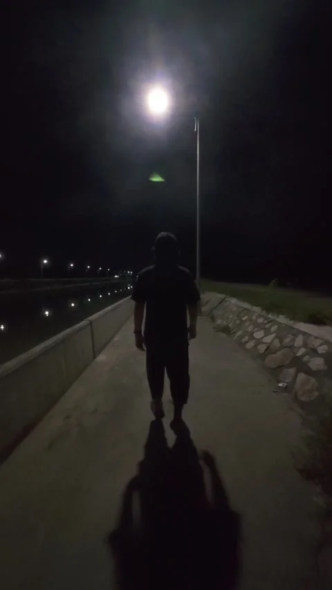 Man walking on the bridge at night in the light of a lantern Video stock 300459243