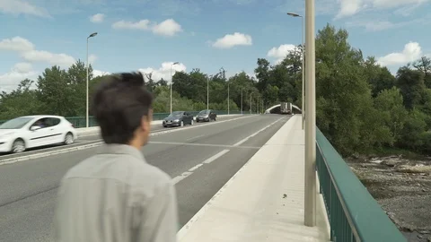 Man walking on a bridge over a river and with cars passing on it, Pau, France Video stock 102155541