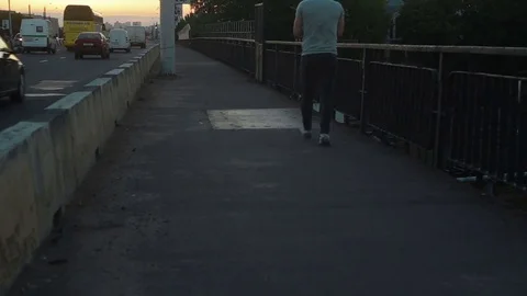 The man is walking on the bridge at sunset Vidéo 78613083