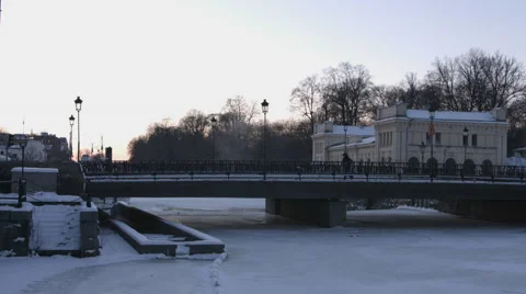 Man walking on a bridge winter time in a small town Stock Footage 64552835