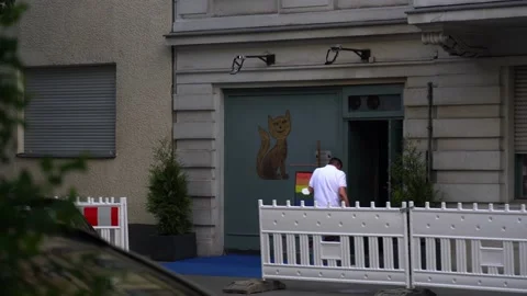 Man walking into building with cat and rainbow pride flag Stock Footage 159665292