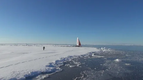 Man walking to a catamaran in the ice floe, Arctic Ocean Stock Footage 104871030