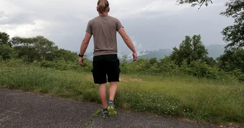 Man is walking close to the mountain edge and raising his hands to the sky. Vidéo 91755538