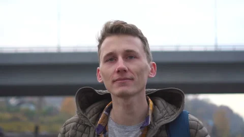 Man walking in cloudy city . Handsome young caucasian man wearing casual jacket Stock Footage 100909404