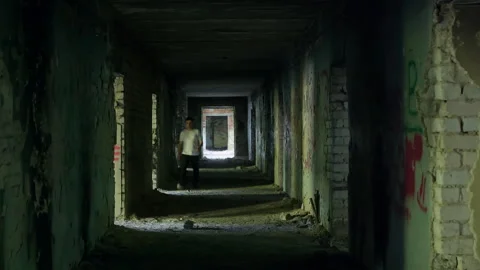 Man walking in dark abandoned corridor Stock Footage 301328346