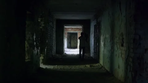 Man walking in dark abandoned corridor waving hands Video stock 304516829