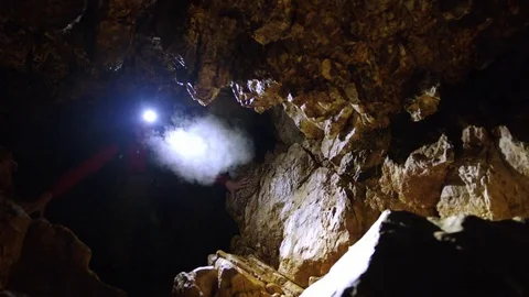 Man Walking In Dark Cave Stockbeeldmateriaal 75174471