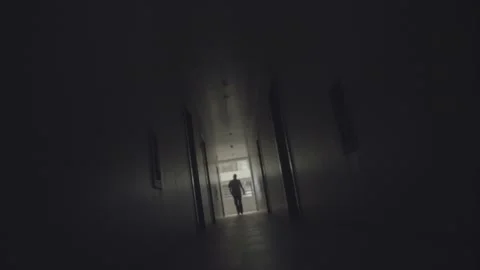 Man Walking in Dark Hallway Stock Footage 188012625