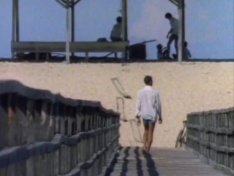Man walking on the deck and fetching something from the sea Stock Footage 79926043
