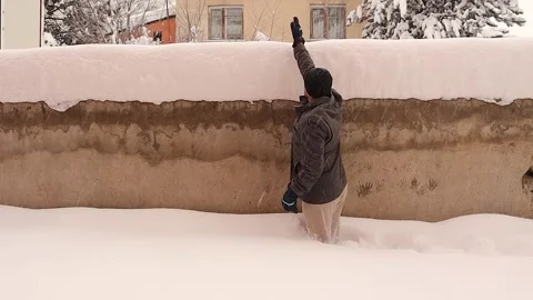 Man Walking in Deep Snow Showing Snow Thickness on Backyard Wall Erzurum Vídeos de archivo 330288544