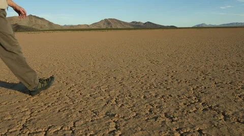 Man walking on a desert playa, dead soil Stock Footage 55831715