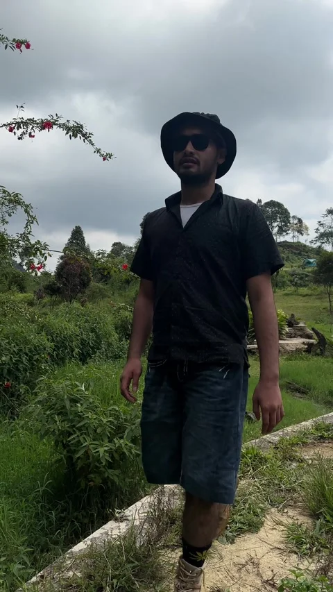 Man Walking on Dirt Path Towards Waterfall in Outdoor Park Vertical Stock Footage 323912700