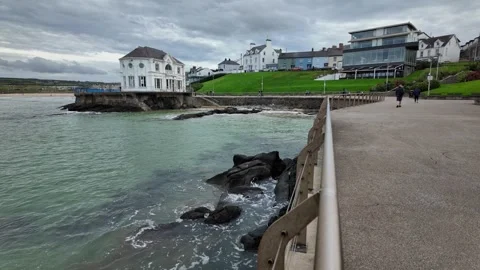 Man Walking Dog Along Seafront by Arcadia Portrush 動画素材 317442725