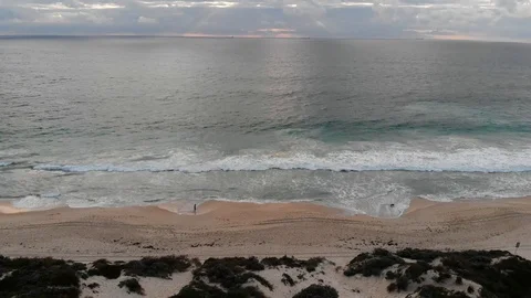 Man walking dog on beach at sunset aerial footage Stock Footage 116098678