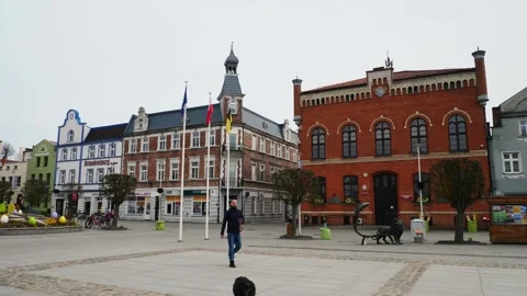Man walking dog in town square, Holy Week decorations, Puck Poland Stock Footage 343897247
