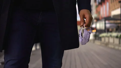 Man Walking Down a Boardwalk with Protective Face Mask in Hand Stock-Footage 132503204