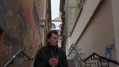 Man walking down into a dark city alley with graffiti and vandalism Stock Footage 311192968