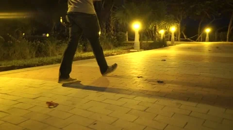 Man walking down Miami Beach lit path Stock Footage 54164853