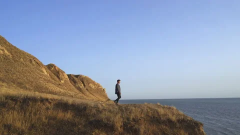 The man walking down the mountain against the seascape Stock Footage 143895683