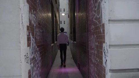 Man Walking Down Narrow Graffiti Covered Alley 스톡 동영상 344618513