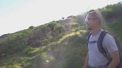 Man walking down a path, overlooking ocean from a cliff, 4k Stock Footage 103436488