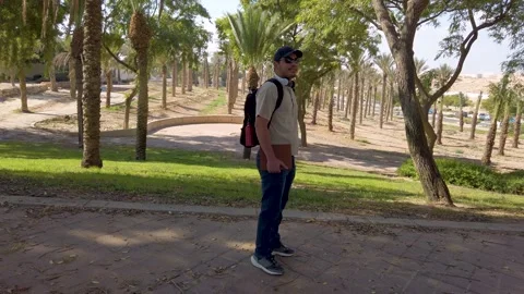 A man is walking down a path in a park Stock Footage 324924377