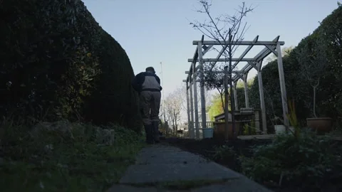 A man is walking down a path with a shovel in his hand Video stock 301618590