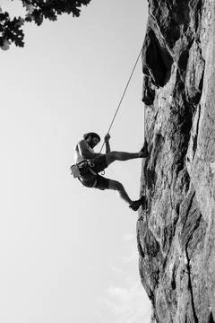 Man walking down the rock after outdoor climbing with his friend Stock Photos
