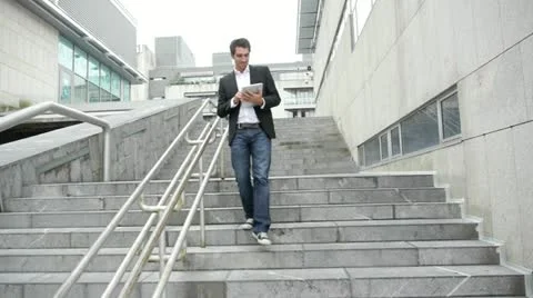Man walking down stairs with tablet Stock Footage 14830136
