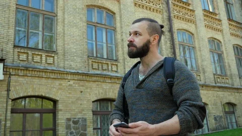 The man is walking down the street and looking at the phone Stock Footage 88782843