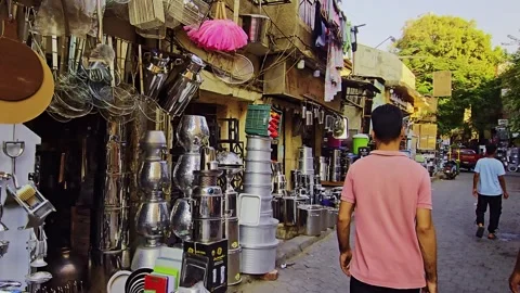 A man walking down a street with a bunch of pots Stock Footage 292251345