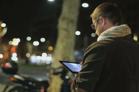 Man walking down the street at night and using tablet, steadycam shot Stock-Footage 37219017