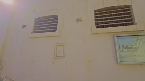 A man walking down a street past a building Stock Footage 291633591