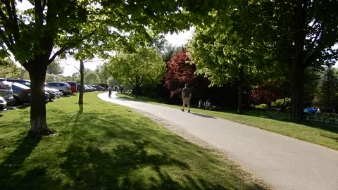 Man Walking Down Summer Pathway In Park As Child On Bicycle Bikes Forward Stock-Footage 154433669