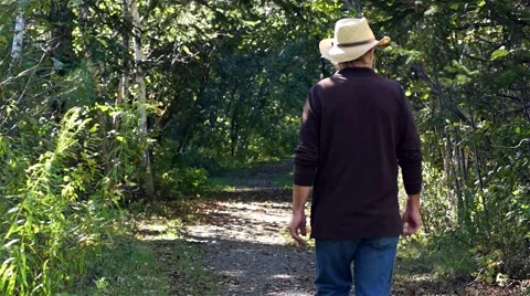 Man walking down a tree lined path 库存影片 48804913