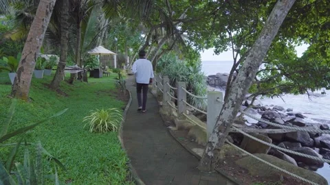 Man Walking Down Tropical Hotel Path Video stock 195720992