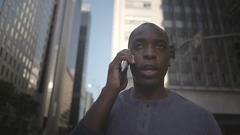 Man walking in downtown while on his phone Video stock 98912370