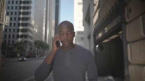 Man walking in downtown while on his phone Video stock 98912924