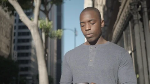 Man walking in downtown while on texting Vidéo 98912585