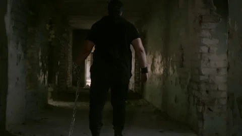 Man walking dragging chains in abandoned building Stock Footage 304949279