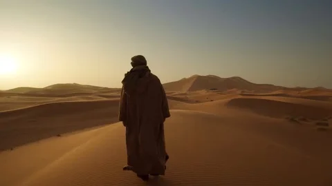 Man walking in the dunes at sunset Morocco Stock Footage 125248526